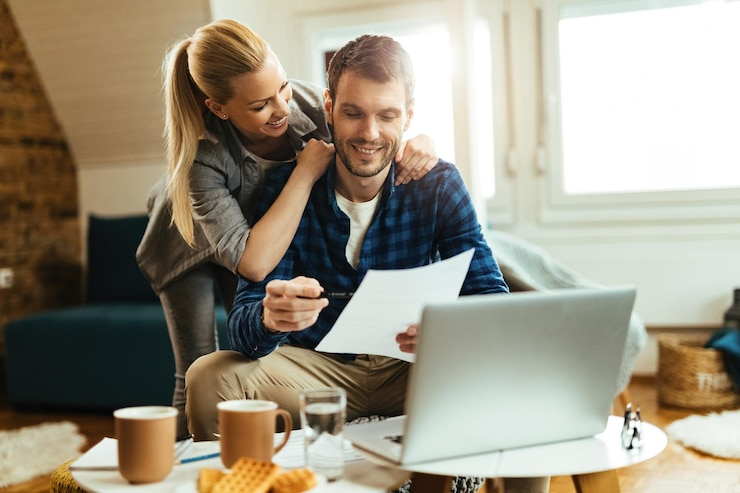 casal feliz analisando seu orcamento domestico enquanto paga a conta em um computador 637285 5653